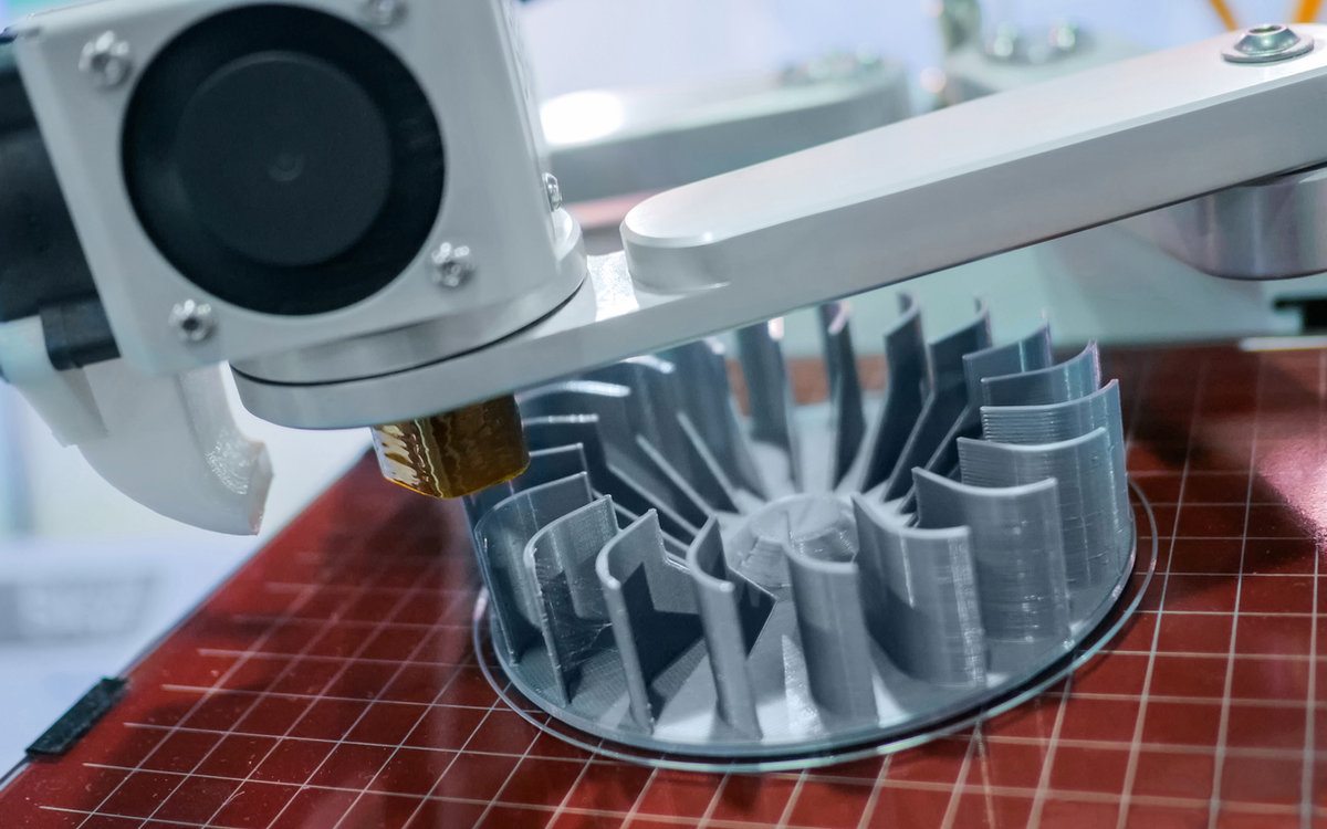 Bancada com impressora 3D e peças impressas